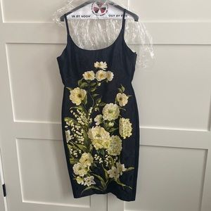 Fitted black dress with floral detail on the front that hits just below the knee